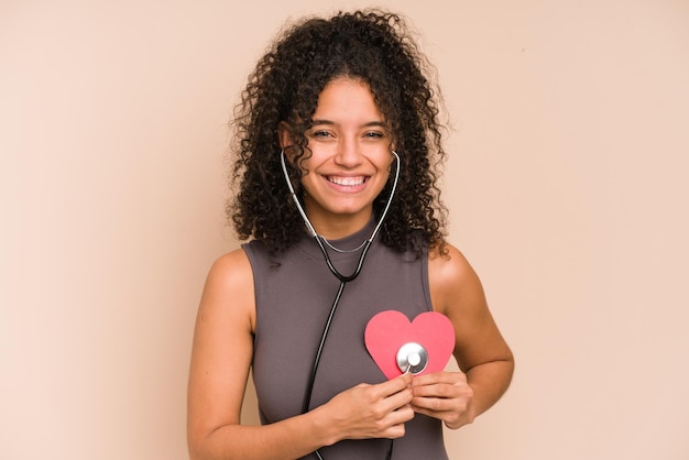 Joven afroamericana escuchando un corazón con un estetoscopio, concepto de amor