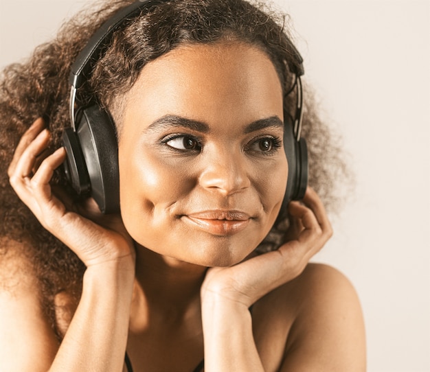 Joven afroamericana escuchando música en auriculares