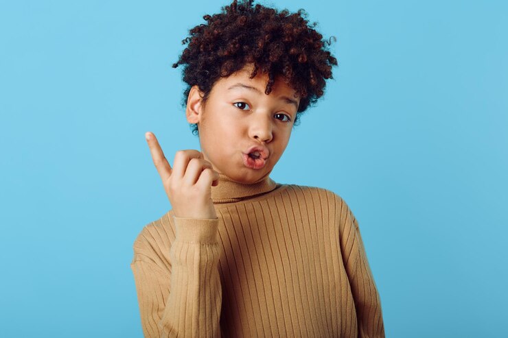 Foto una joven afroamericana expresando curiosidad y alegría con su dedo en un fondo azul brillante