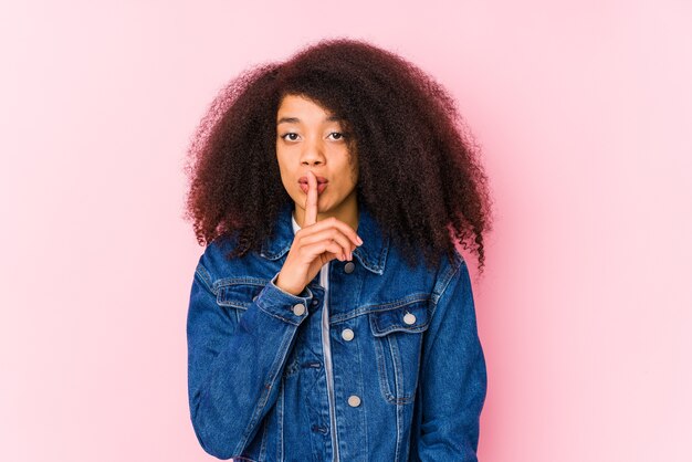 Joven afroamericana guardando un secreto o pidiendo silencio.