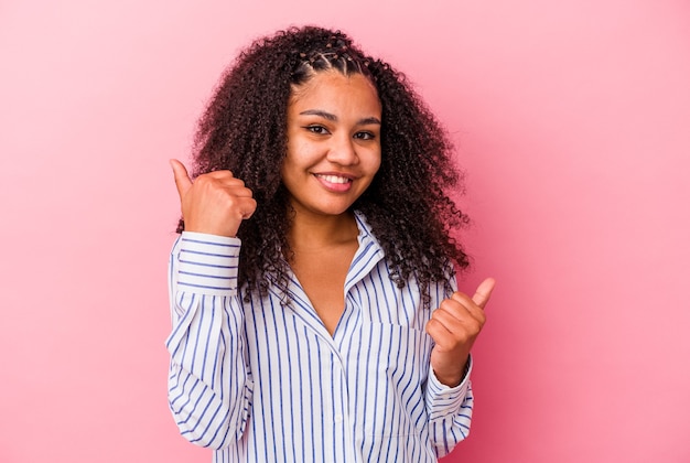 Joven afroamericana levantando ambos pulgares, sonriente y confiada.