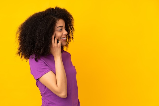 Joven afroamericana manteniendo una conversación con el teléfono móvil con alguien