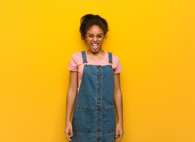 Joven afroamericana negra con ojos azules divertido y amistoso showngue