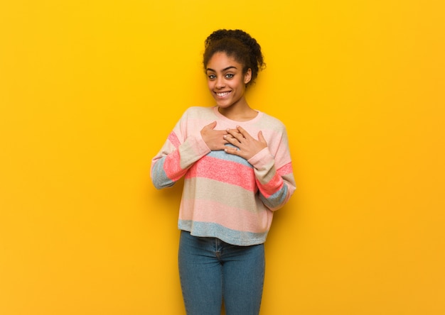 Joven afroamericana negra con ojos azules haciendo un gesto romántico