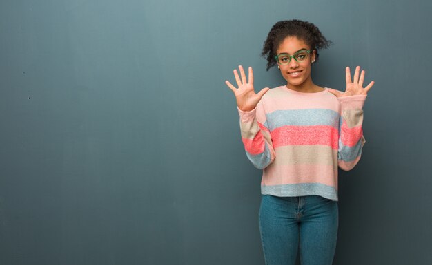 Joven afroamericana con ojos azules mostrando el número diez