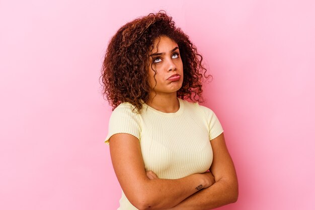 Joven afroamericana en rosa cansada de una tarea repetitiva.