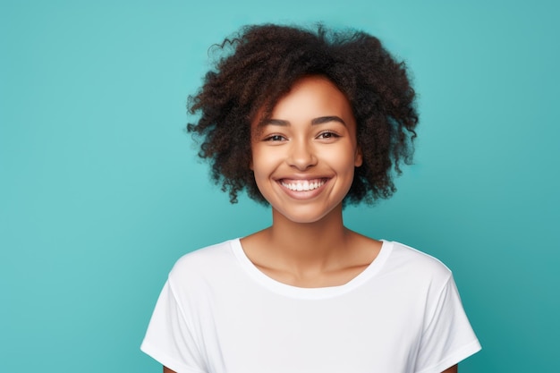 Una joven afroamericana sonriendo y con una camiseta blanca sobre un fondo turquesa