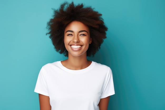 Una joven afroamericana sonriendo y con una camiseta blanca sobre un fondo turquesa