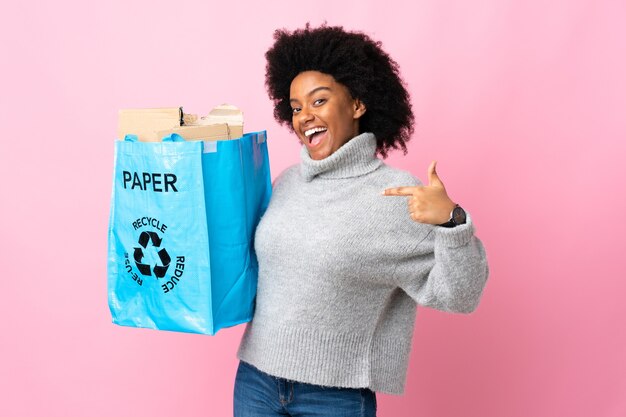 Joven afroamericana sosteniendo una bolsa de reciclaje orgullosa y satisfecha de sí misma