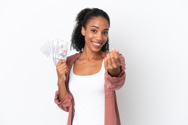 Joven afroamericana tomando un montón de dinero aislado sobre fondo blanco haciendo gesto de dinero