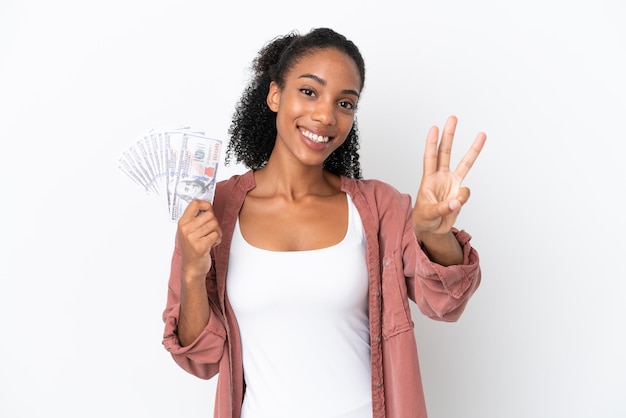 Joven afroamericana tomando mucho dinero aislada de fondo blanco feliz y contando tres con los dedos