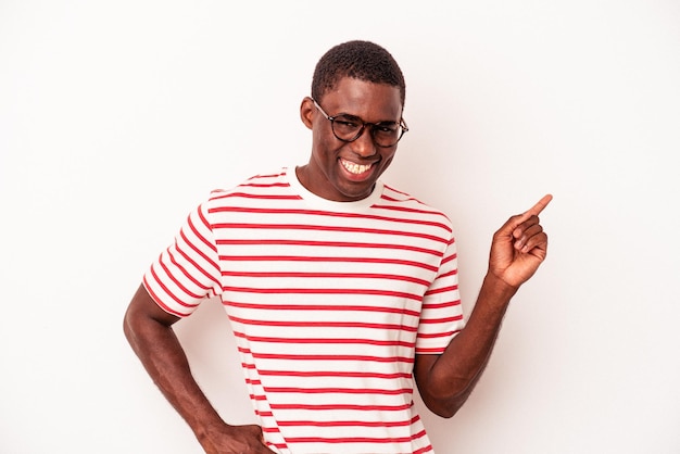 Joven afroamericano aislado de fondo blanco sonriendo alegremente señalando con el dedo índice.