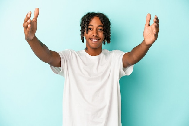 Joven afroamericano aislado sobre fondo azul celebrando una victoria o un éxito, está sorprendido y consternado.