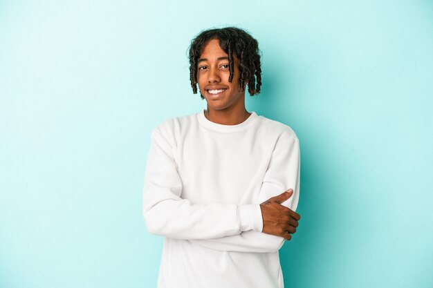 Joven afroamericano aislado sobre fondo azul feliz, sonriente y alegre.