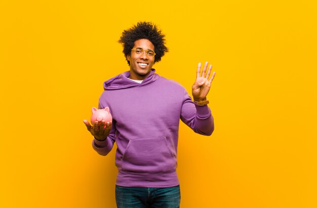 Joven afroamericano con una alcancía