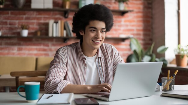 Foto joven afroamericano alegre con camisa a rayas trabajando remotamente en una computadora portátil debido a la desigualdad social