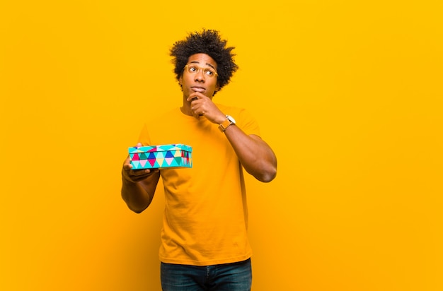 Joven afroamericano con una caja de regalo