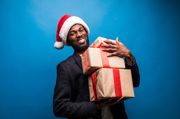 Joven afroamericano que llevaba un gorro de Papá Noel ofreciendo regalos