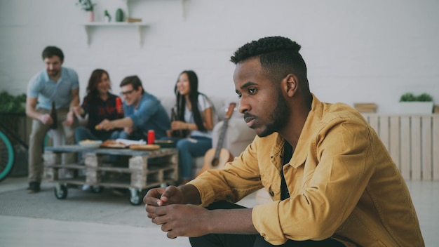 El joven afroamericano se siente molesto y aislado mientras sus amigos celebran la fiesta en casa en el interior