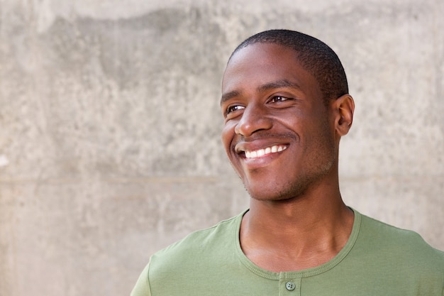 Joven afroamericano sobre fondo gris sonriendo