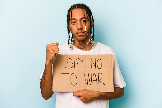Joven afroamericano sosteniendo un cartel de decir no guerra aislado de fondo azul