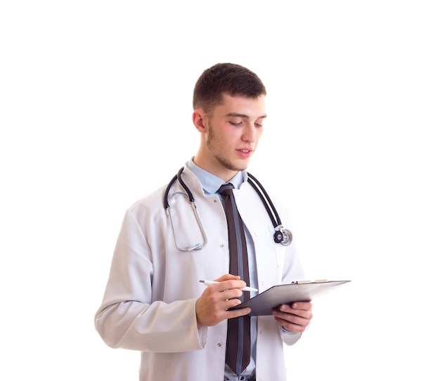 Joven agradable con cabello castaño con camisa azul, corbata y bata de doctor con estetoscopio