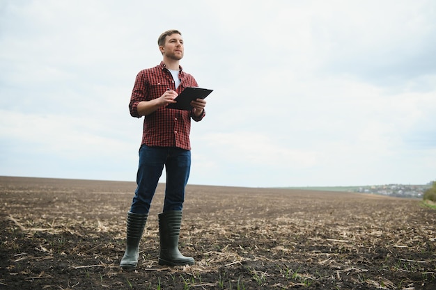 Joven agricultor en un campo de maíz de siembra controlada