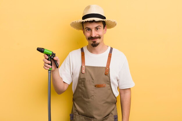 Joven agricultor con un concepto de jardinería con manguera