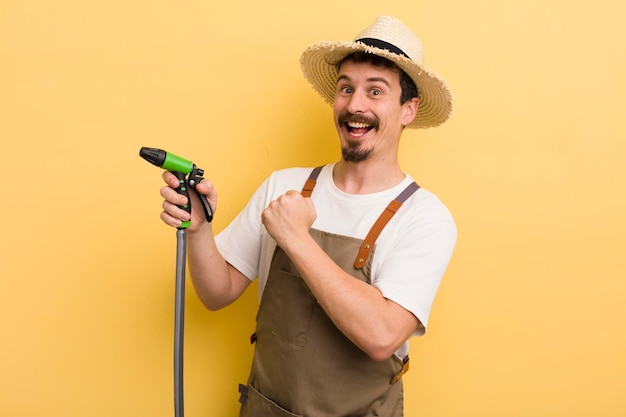 Joven agricultor con un concepto de jardinería con manguera