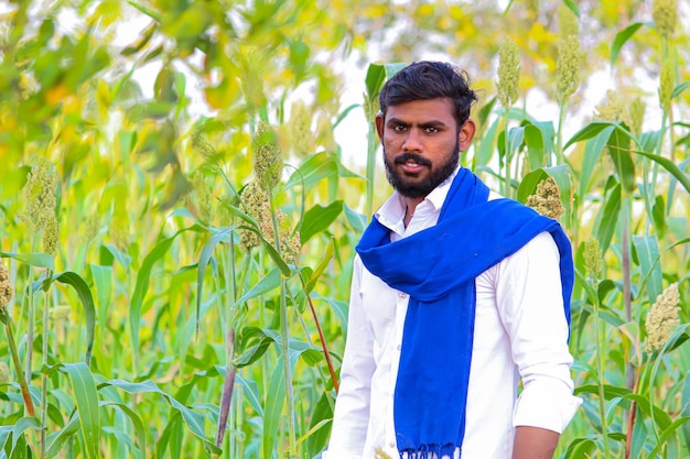 Joven agricultor indio en el campo de sorgo