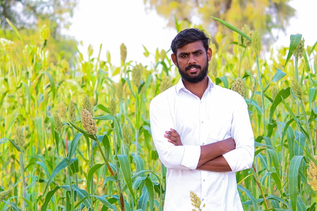 Joven agricultor indio en el campo de sorgo