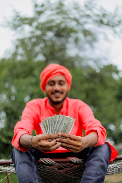 Joven agricultor indio contando y mostrando dinero