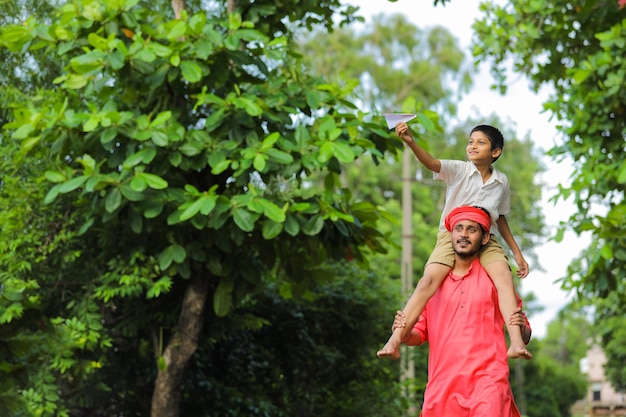 Joven agricultor indio jugando con su hijo