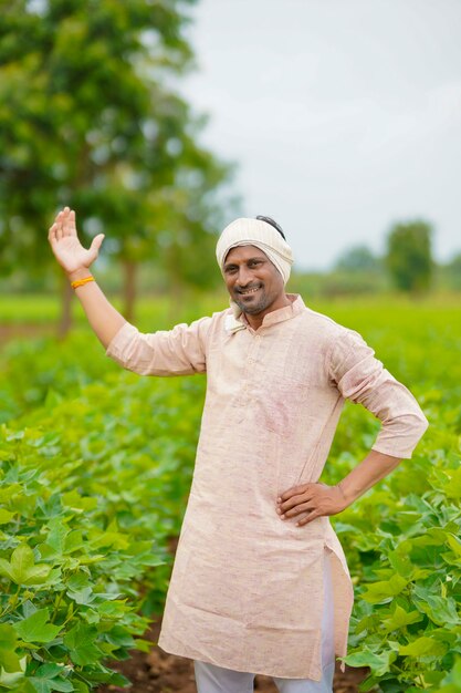 Joven agricultor indio de pie en el campo de la agricultura de algodón.