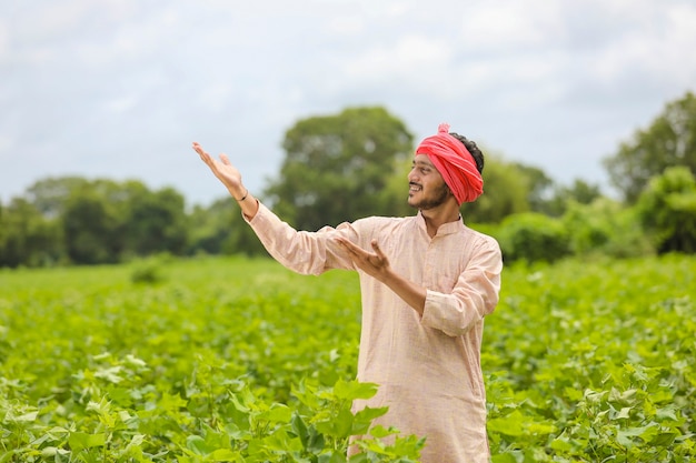 Joven agricultor indio de pie en el campo de la agricultura.