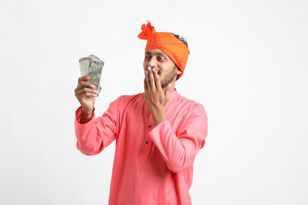 Joven agricultor indio posando con moneda