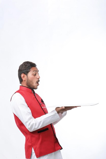 Joven agricultor indio con ropa tradicional y expresión de fondo blanco.