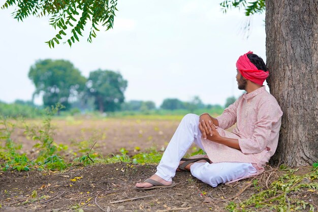 Joven agricultor indio sentado en el campo de la agricultura.