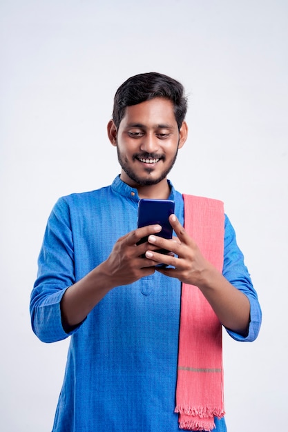 Joven agricultor indio con smartphone sobre fondo blanco.