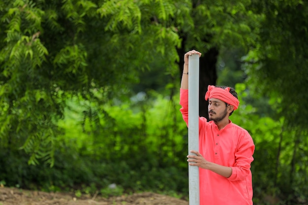 Joven agricultor indio sosteniendo una pipa