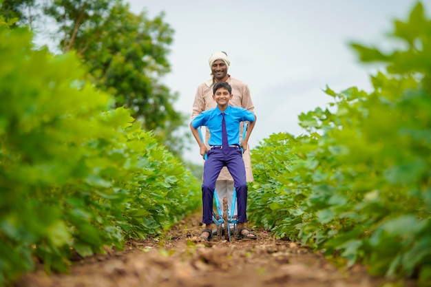 Joven agricultor indio con su hijo en el campo de la agricultura verde.
