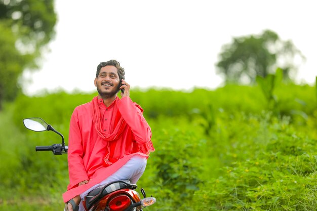 Joven agricultor indio con un teléfono inteligente