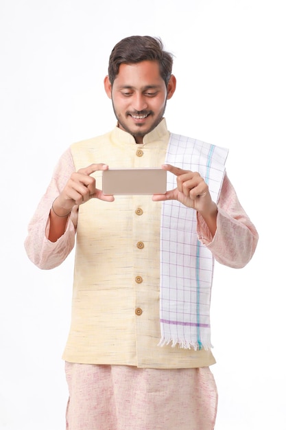 Joven agricultor indio usando un teléfono inteligente con fondo blanco.