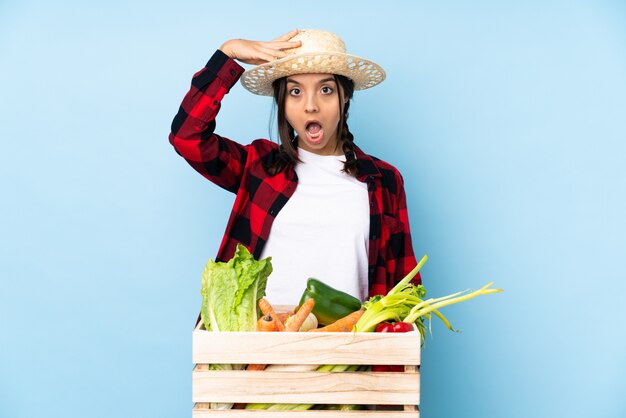 Joven agricultor Mujer con verduras frescas en una canasta de madera acaba de darse cuenta de algo y tiene la intención de encontrar la solución