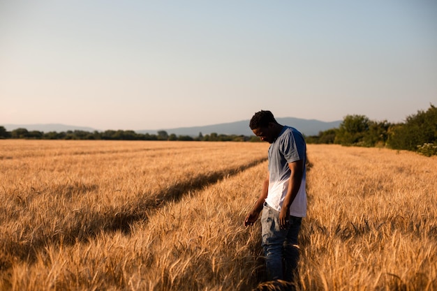 Joven agricultor parado en medio del campo