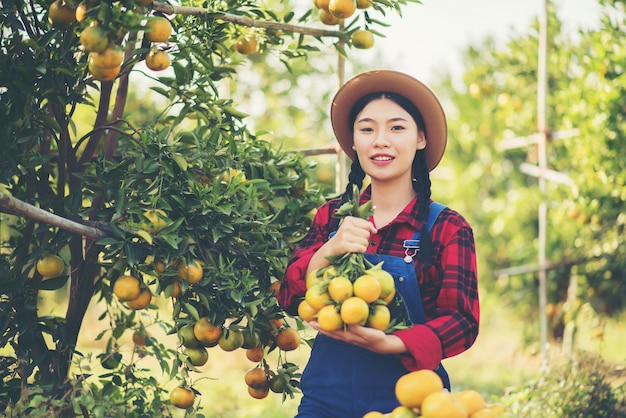 Joven agricultor sosteniendo dulces naranjos en las manos