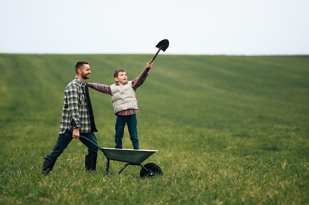 El joven agricultor y su hijo se divierten en el campo.