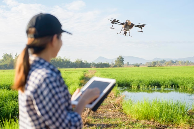 Una joven agricultora inteligente con tableta en el campo, innovaciones de alta tecnología y agricultura inteligente