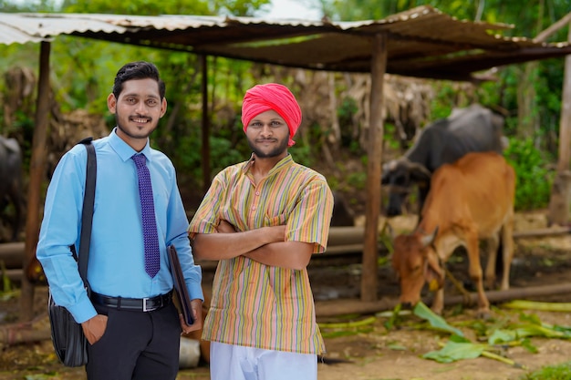 Joven agrónomo indio o oficial visitando al agricultor en su finca