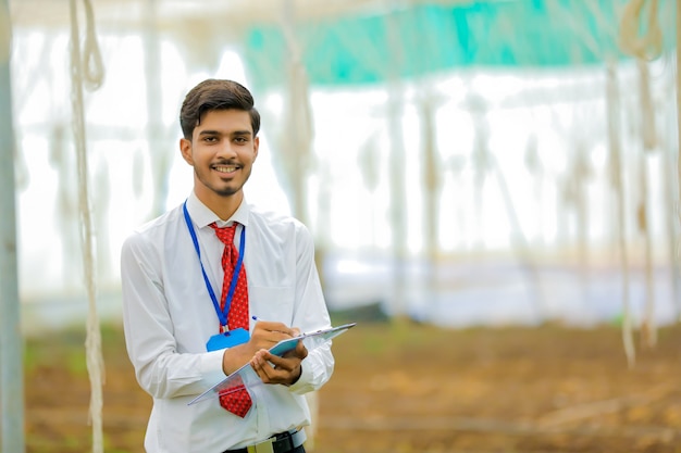 Joven agrónomo indio recolectando información en invernadero
